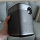 The XGIMI Halo+ projector being held in one hand.